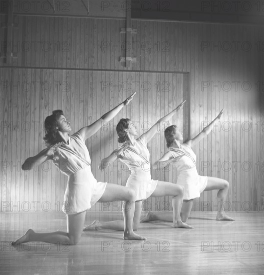 Gymnastics in the 1940s. Three young female gymnasts are practicing together and doing the same movement. 1945 Sweden Photo Kristoffersson ref M107-1