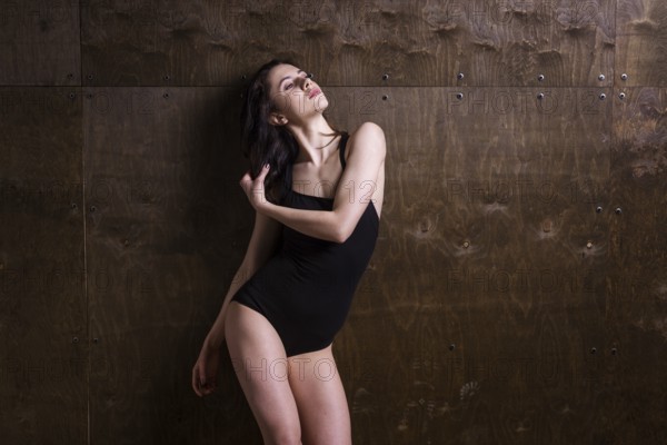 Young woman dancer. Young woman modern dance. Skill ballet dancer posing. dancer posing near the wall. full length portrait of a flexible young woman posing near the wall. Dancer, flexibility