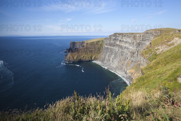 The famous Cliffs of Moher are sea cliffs located at the southwestern edge of the Burren region in County Clare, Ireland. They run for about 14 kilometres