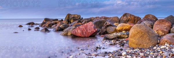 Panoramic photo of stones at the seaside with gentle water and beautiful details of nature long exposure. Big stones at the seaside in long exposure photography a beautiful impression of nature. Panoramic photography