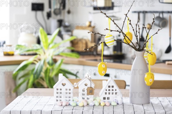 Key to house of cozy home with Easter decor with rabbit and eggs on table of kitchen. Building, design, project, moving to new house, mortgage, insurance, rent and purchase real estate