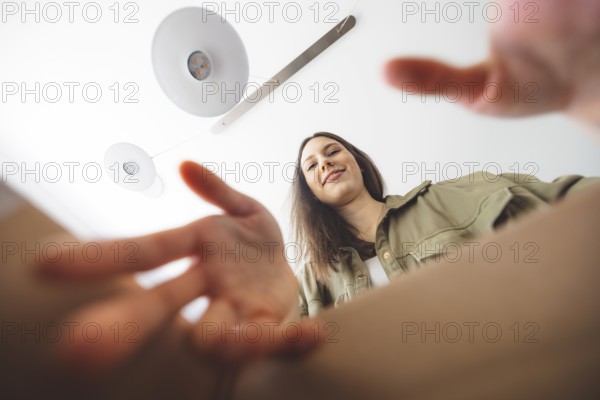 Young caucasian woman receiving a big box of her online orders. Woman opening the package, getting excited to see the stuff she bought.