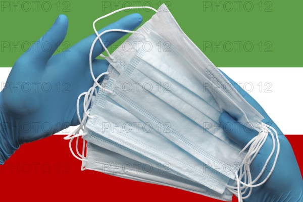 Doctor holding face masks in hands medical blue gloves on background national flag Islamic Republic of Iran. Concept coronavirus quarantine, pandemic outbreak, grippe, hygiene. Surgical face bandage