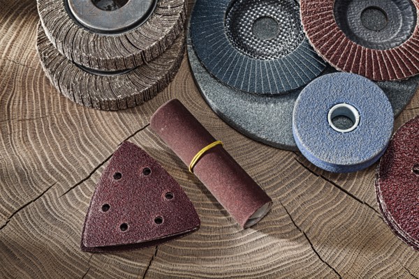 Abrasive Wheels And Papers On Wood Background