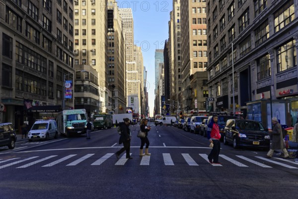 Manhattan, New York City, New York, USA, North America, Street scene with pedestrians in the city, surrounded by tall buildings under a blue sky, North America