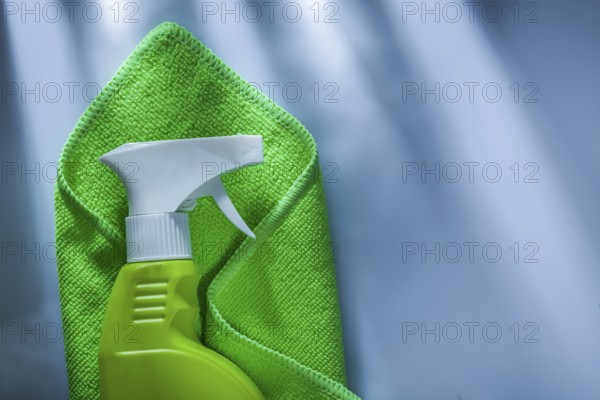 Green washing rag sprayer on white surface