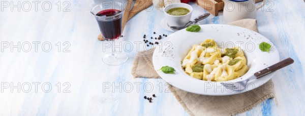 Tortellini di formaggio with basil pesto and cheese sauce