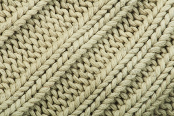 Old knit sweater background. Beige color. Studio shot
