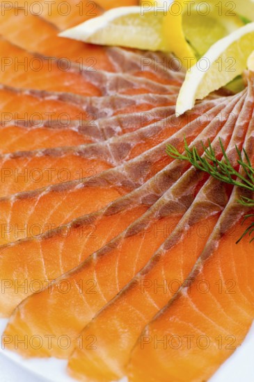Sliced smoked salmon served with lemon slices