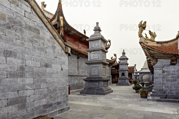 Inner courtyard with grey stone walls in traditional Asian architecture and decorated roofs, The temple complex at Fansipan near Sa Pa in Vietnam
