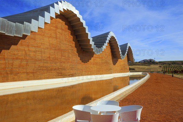 Fragment of the facade is reflected in the pool. Winery - bodega Bodegas Ysios. Journey to the warm Spanish autumn. Laguardia. The sunset