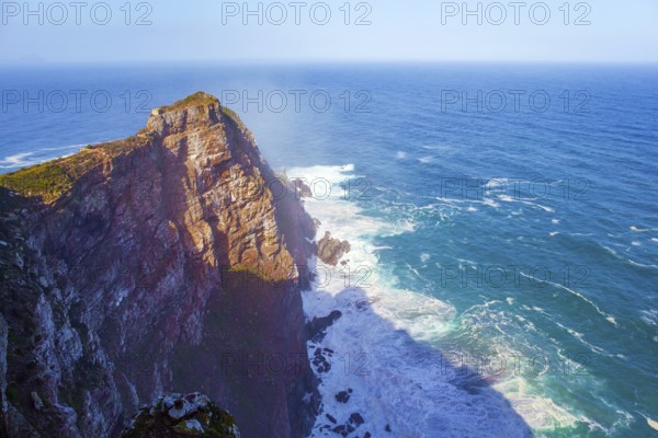 Bird's-eye view. South Africa. Powerful ocean surf. Cape of Good Hope at the southern tip of the Cape Peninsula. White foam of the ocean surf. Bright sunny summer february day