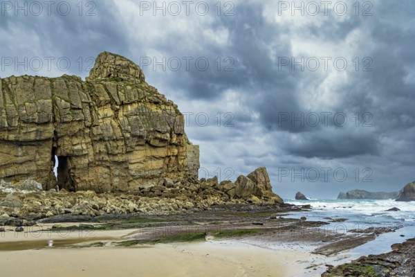 Noon on the beach of Playa di Arnia, Spain. Rocky picturesque ocean coast. Cantabria. Windy stormy day on the Atlantic coast