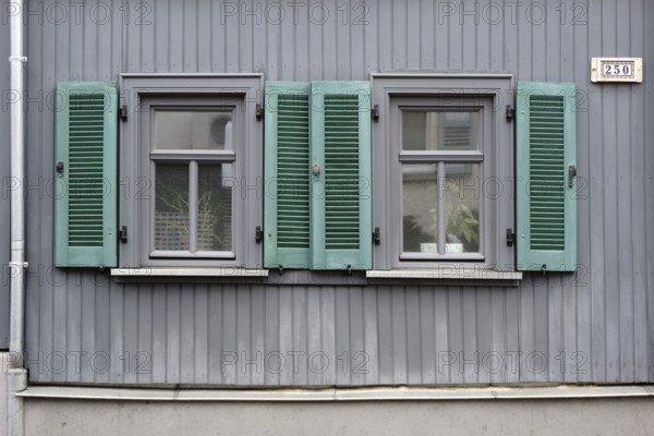 A terraced house with nostalgic wooden shutters and plank walls
