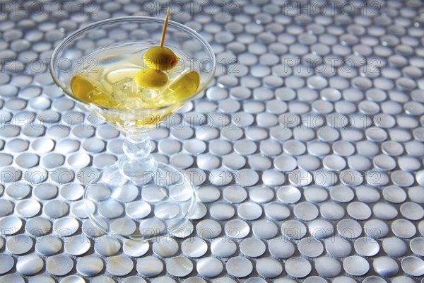 White vermouth cocktail on modern stainless steel circle pattern table