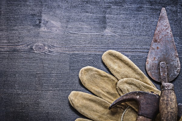 Vintage dusted and rusted tools hammer and spattle on glove