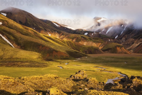 National Park Landmannalaugar, Iceland. Sunrise in the Arctic. Striped mountains of rhyolite covered sunshine
