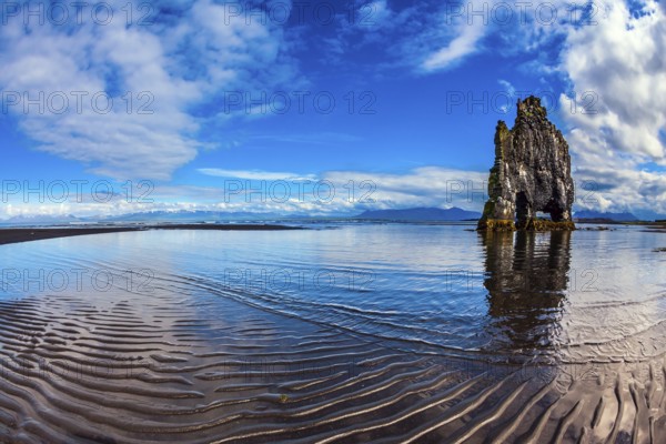 Rock Hvitserkur on the sea beach in the form of a huge elephant. Ocean tide at sunset. The north coast of Iceland. The concept of northern extreme tourism