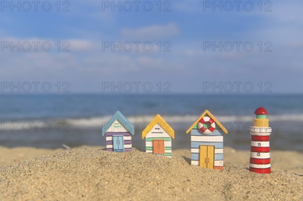 Miniature wooden huts and lighthouse at the beach