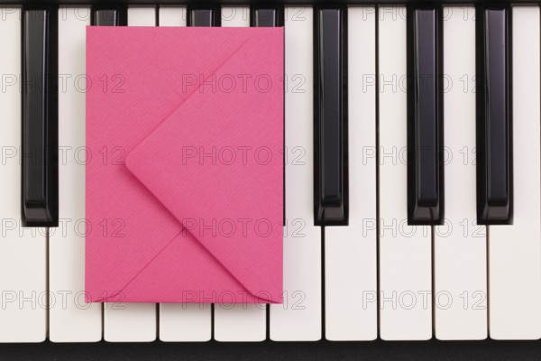 Funny arrangement envelope on the piano keybords - Flat lay image