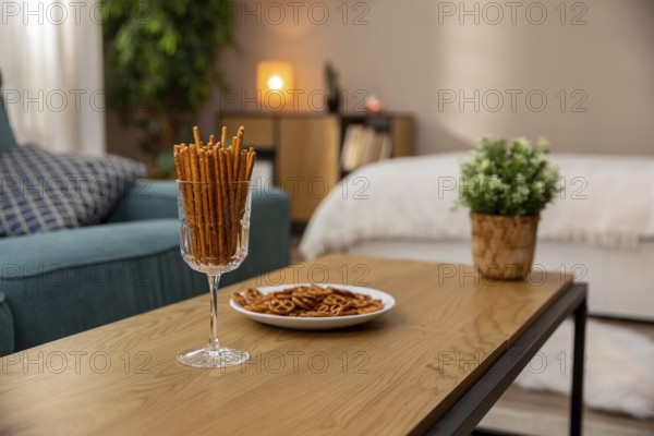This is a stylish living space that includes pretzel snacks and indoor plants to create a cozy, inviting ambiance