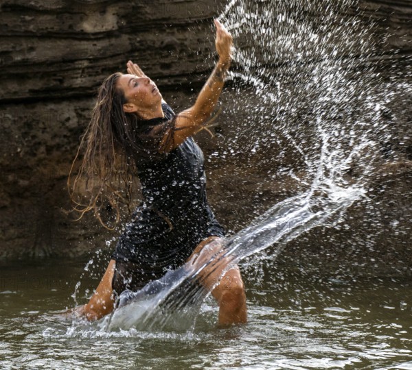 Middle-aged woman dancing and throwing water in the air, Maioris beach, llucmajor, Majorca, Balearic Islands, Spain, Europe