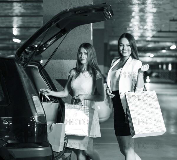 Two young shoppers on a car parking