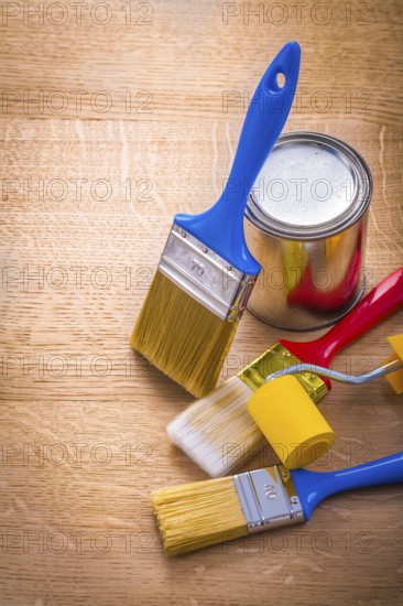 Set of paint brushes roller and can on wooden board