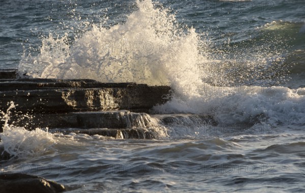 Splashing stormy windy sea waves on a rocky seashore. Storm weather, ocean
