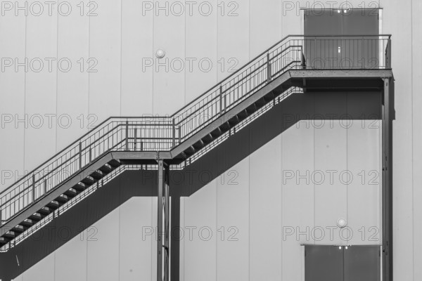 Greyscale shot outdoor stairway to the building in the sun