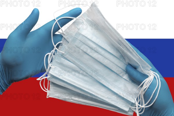 Doctor holding face masks in hands surgical blue gloves on background national flag of Russia. Concept pandemic outbreak, grippe, coronavirus quarantine, hygiene. Medical antibacterial face bandage