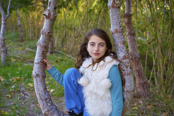 Autumn kid girl relaxed in forest with green canes background