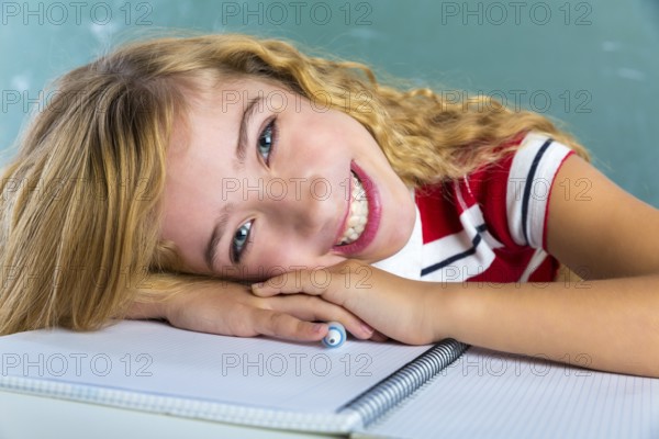 Happy student expression schoolgirl in classroom desk at school green chalk board