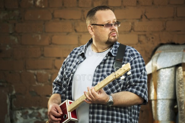 Man playing his three string cigar box guitar