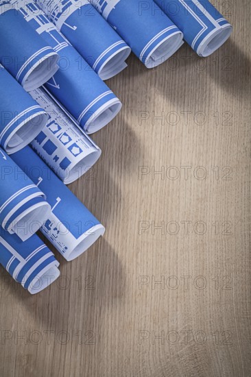 Assortment of blue blueprint rolls on wooden board