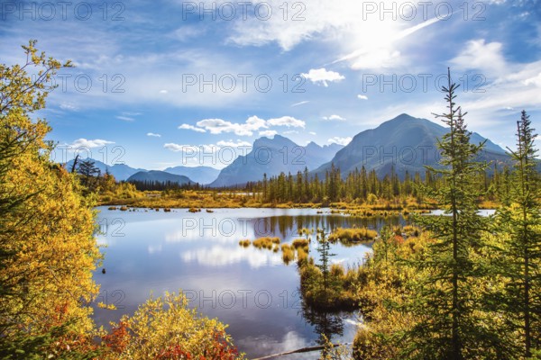 Grandiose landscape in the Rocky Mountains of Canada. Lake Vermillon among the yellow fall foliage of birches and aspens. The magic of northern Indian summer