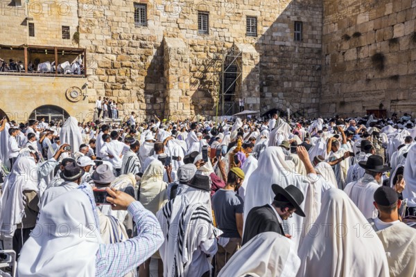 The ceremony at the Western slope of the Temple Mount in Jerusalem. Jews praying in festive white Tallit. The blessing of the Cohanim. Israel. The concept of pilgrimage, religious and photo tourism