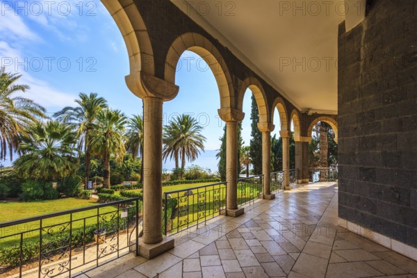The basilica is surrounded by gallery with columns. Subtle shade of palms. Church Sermon on the Mount - Mount of Beatitudes