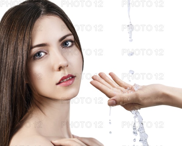 Beautiful woman face and splashes of water in hand. Cleansing and moisturizing concept