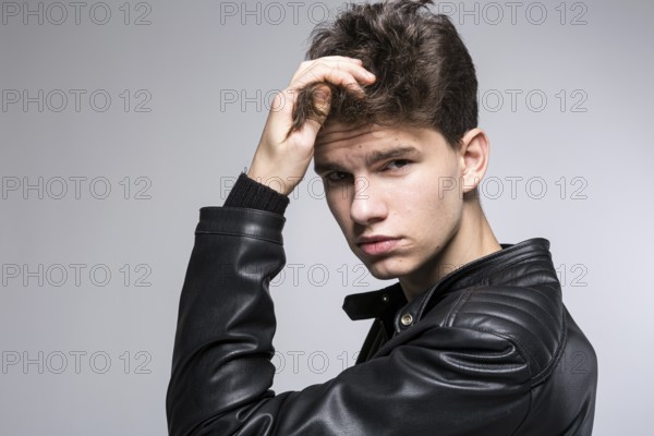 Hair care, health and wellness concept. portrait Of Confident, Charismatic man Touches With Hand, Adjusts Hairstyle. Male hair health concept. young fashion model with highlighted haircut