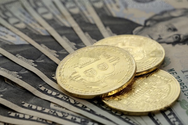 Virtual cryptocurrency money Bitcoin golden coins on United States US twenty dollar bill ($20) with the faces of President Andrew Jackson