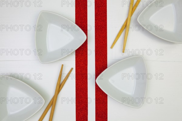 Ceramic bowls and bamboo chopsticks for sushi food with on the white wooden table.Top view. Flat Lay Image