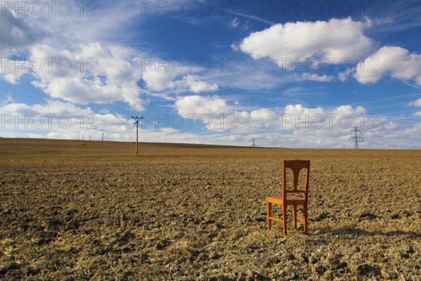 Old wooden chair on the empty field after harvest