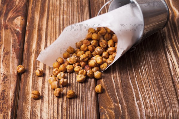 Spicy baked chickpeas in a metal pail on the wooden background