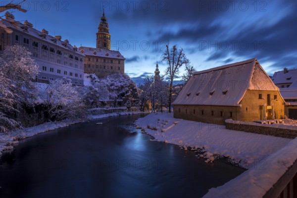 Winter view of Cesky Krumlov, picturesque houses under the castle with snow-covered roofs. Narrow streets and the Vltava river. Travel and Holiday in Europe. Christmas time. UNESCO World Heritage. Czech Republic