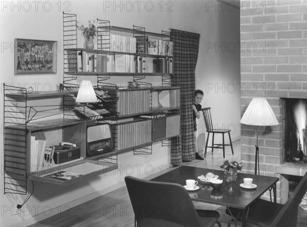 The designers of the Swedish String shelf. Kajsa Strinning. Born January 27 1922, dead December 20 2017. The Architect couple Nisse Strinning (1917-2006) and Kajsa Strinning (1922-2017) debuted as designers with a humble plate rack using steel wire, a technique that would be refined over the years. In 1949, they created a Scandinavian design classic when the String shelf won the Bonnier Folk Library competition. A few years later, in 1954, String earned them their first international design prize, a gold medal at the Milan Triennial. As recently as 2020, String® was awarded the Long Life Design award in Japan. Picture taken in an home with the String shelf system mounted on the wall