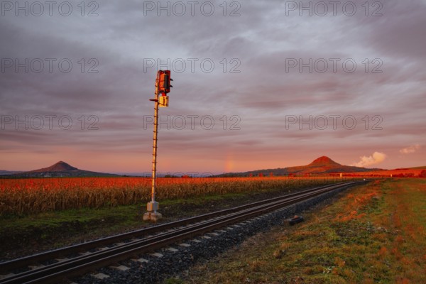 Morning train to the hell. Old Railway tracks running through a field stretch to rural countryside at dramatic sunrise