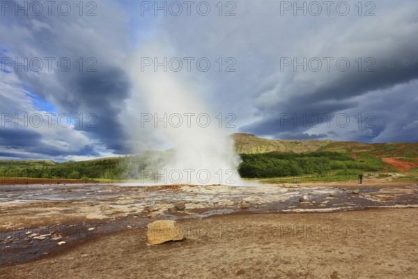 Iceland in the summer. Gushing geyser Strokkur. High column of hot water and steam from the crater of the geyser