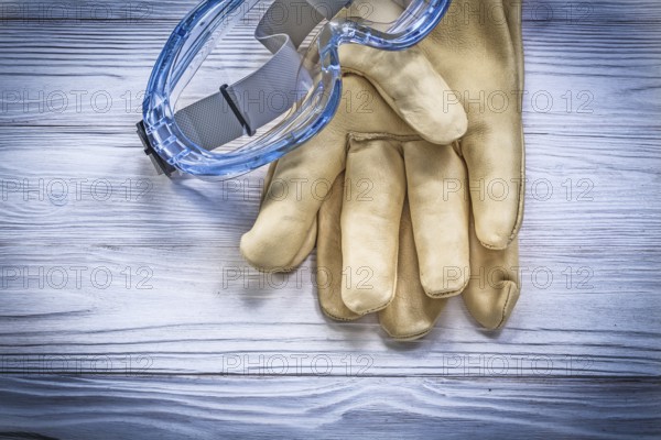 Safety spectacles gloves on wooden board construction concept