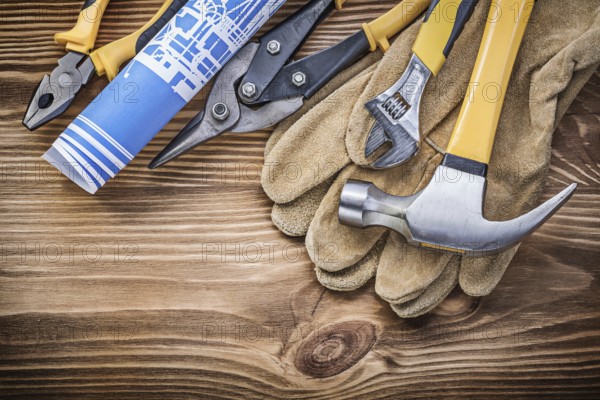 Blueprint protective gloves claw hammer gripping tongs tin snips adjustable spanner on wooden board